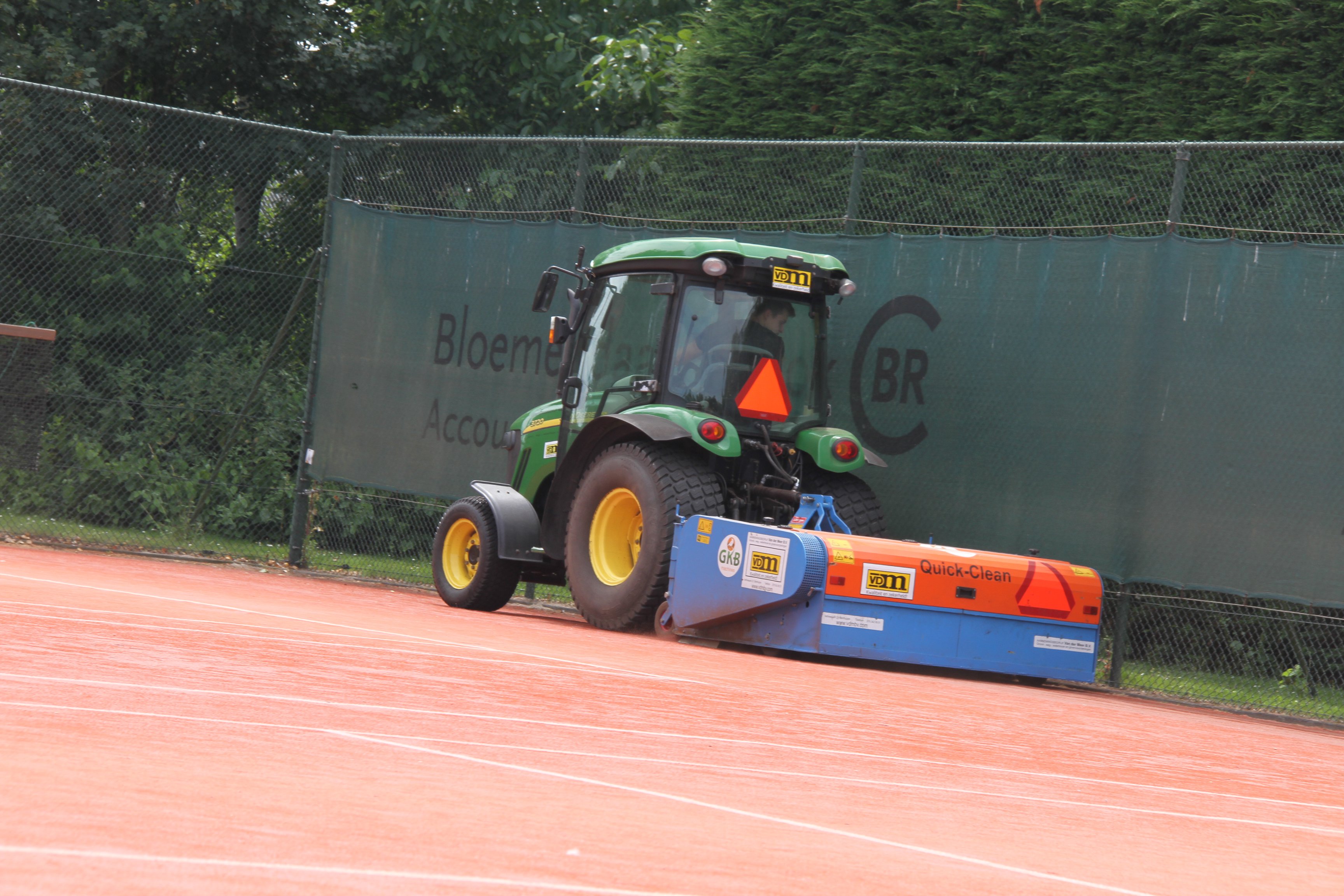 Machine bezig op een tennisbaan